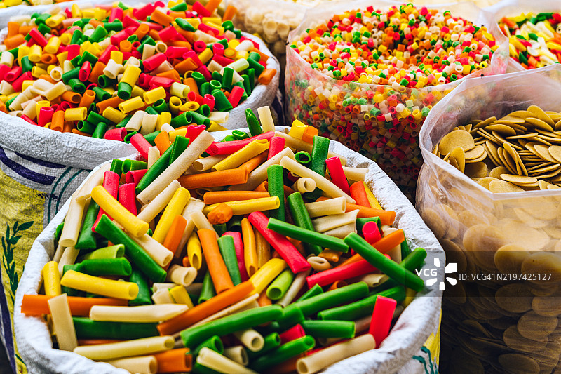德里一个充满活力的市场摊位上色彩缤纷的意大利面种类展示图片素材