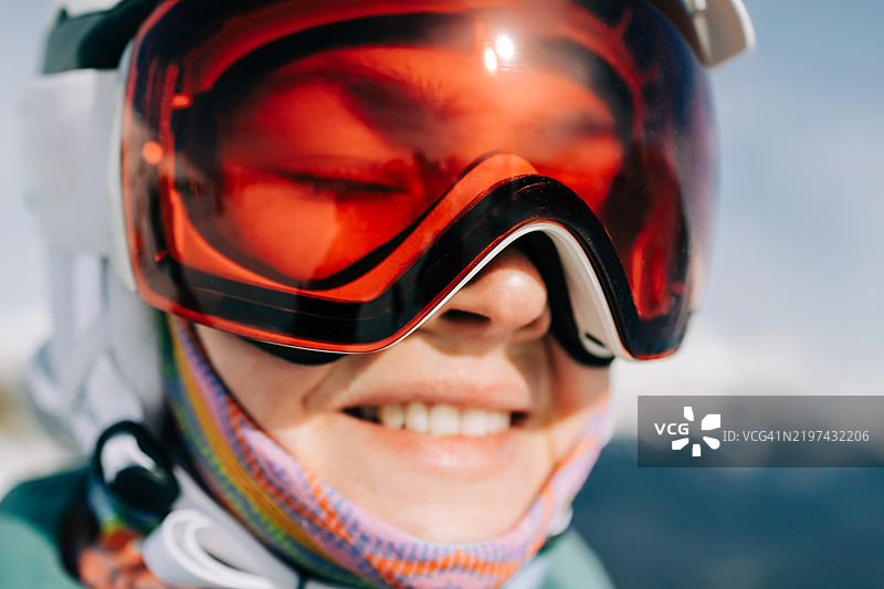 微笑的滑雪者戴着红色滑雪护目镜，享受冬季假期图片素材