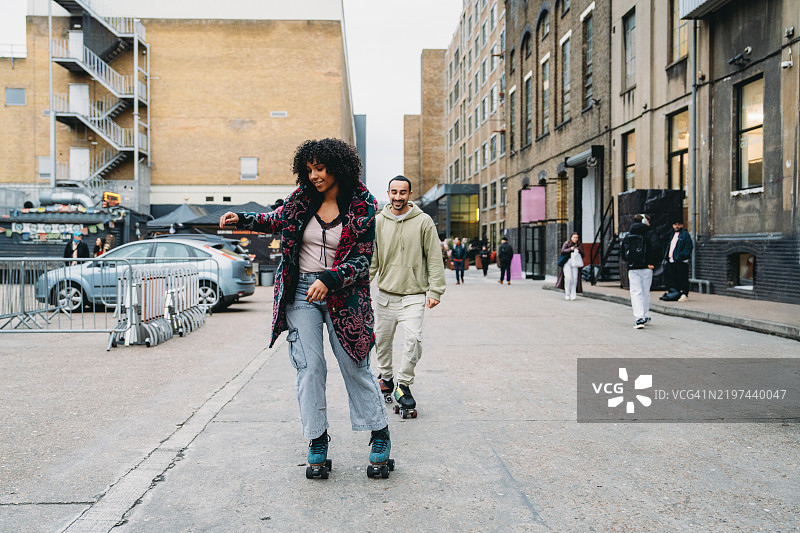 年轻情侣在城市环境中滑旱冰图片素材