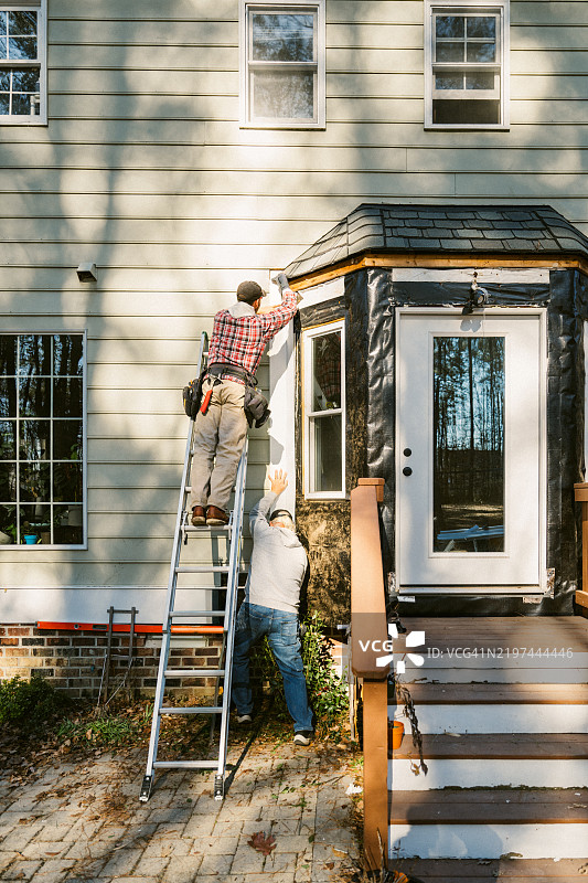 建筑工人在修理房子的外墙板图片素材