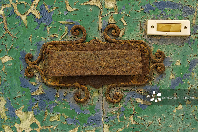 特写,古老破旧的前门,带有生锈的信箱和泛黄的门铃,位于意大利利古里亚大区因佩里亚省的切尔沃历史中心。图片素材