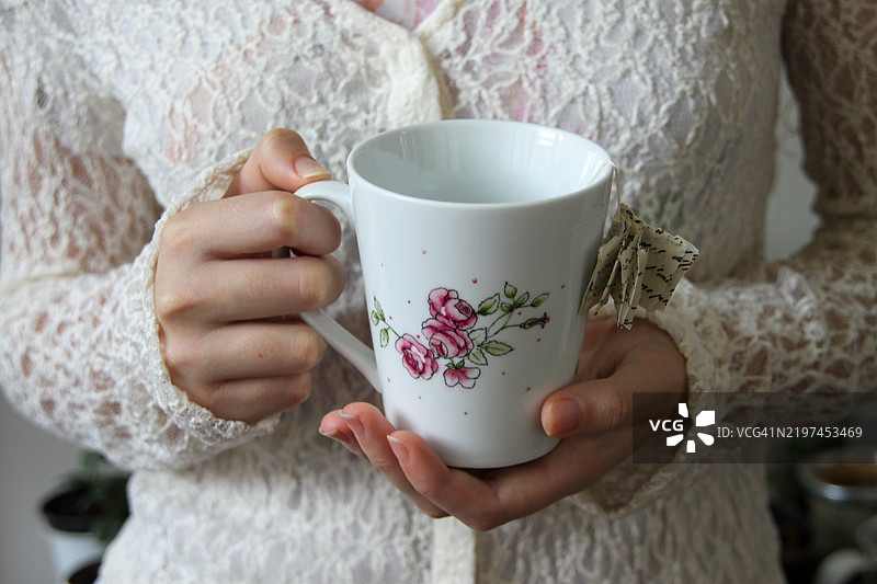 一个少女的手握着一个杯子图片素材