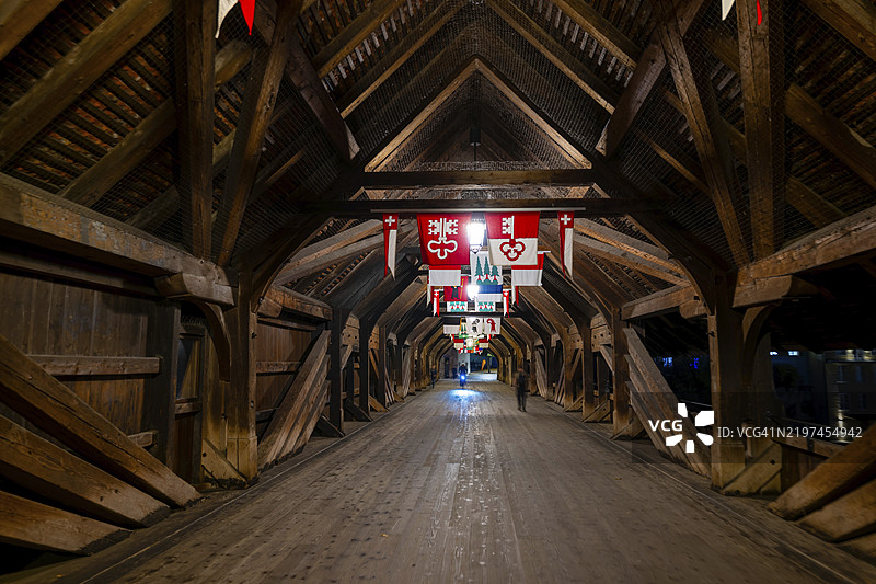 在瑞士索洛图恩州奥尔滕的阿尔河上，夜晚的老历史木桥内，悬挂着旗帜。图片素材