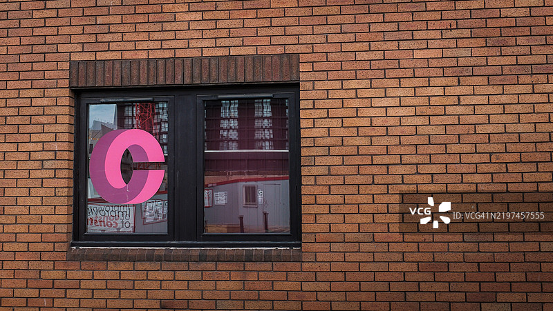 伯明翰砖墙上的粉色字母C窗户图片素材