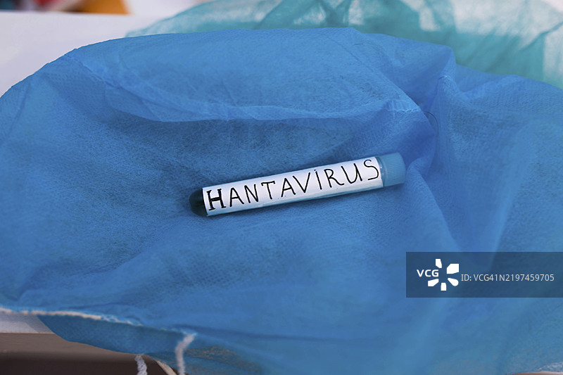 一个标有汉坦病毒的试管，背景为蓝色布料图片素材