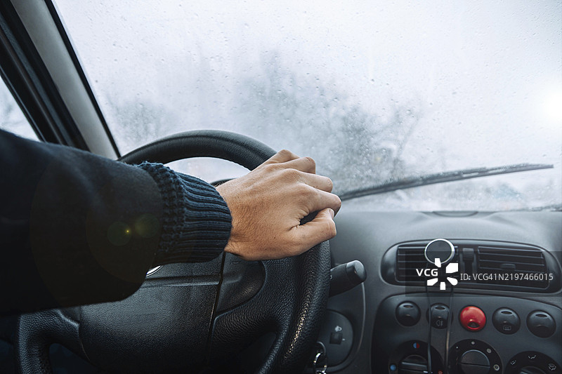 雾气弥漫的环境中，手握方向盘，仪表盘控制装置清晰可见图片素材