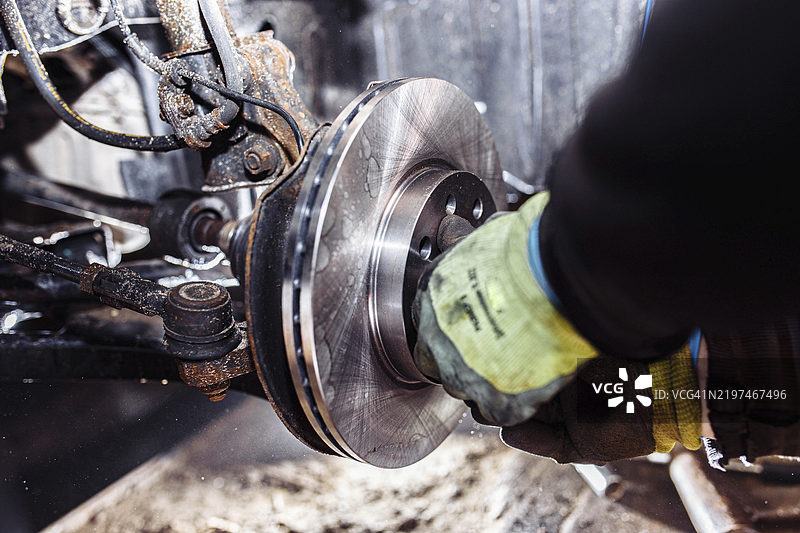 机械师在车间调整刹车系统部件，专注于手部操作图片素材