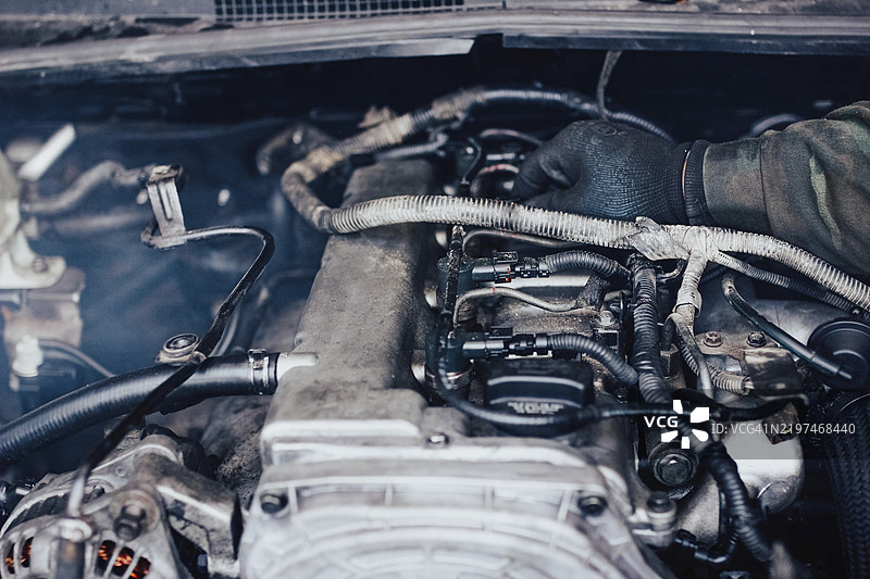 聚焦于机械师的手在精细的发动机部件上工作图片素材