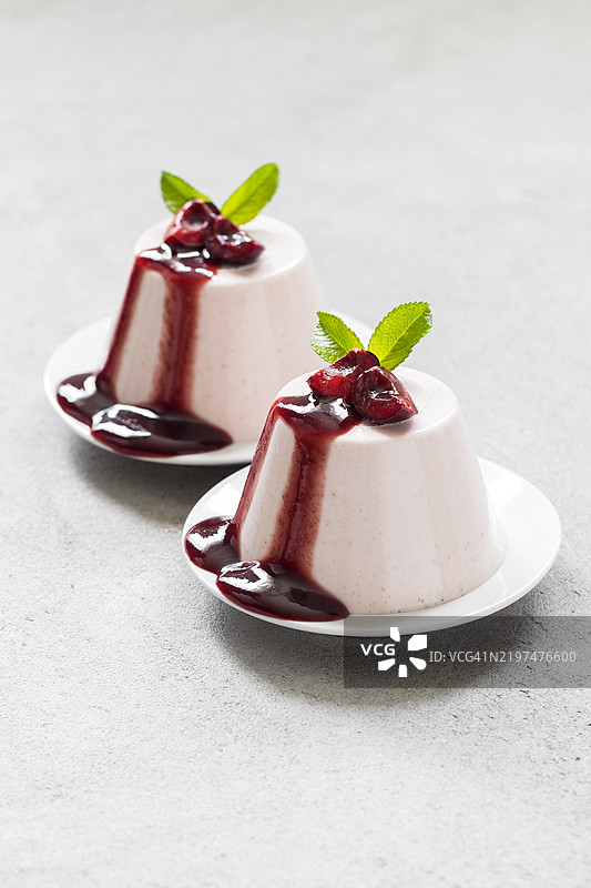 樱桃奶油布丁，意式奶冻。配樱桃酱。放在盘子里。浅色背景。特写。图片素材