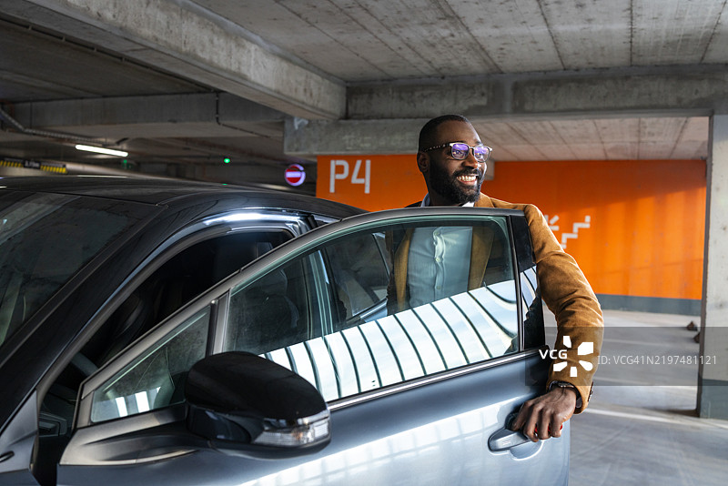 男子在停车场下车时享受阳光明媚的时刻图片素材