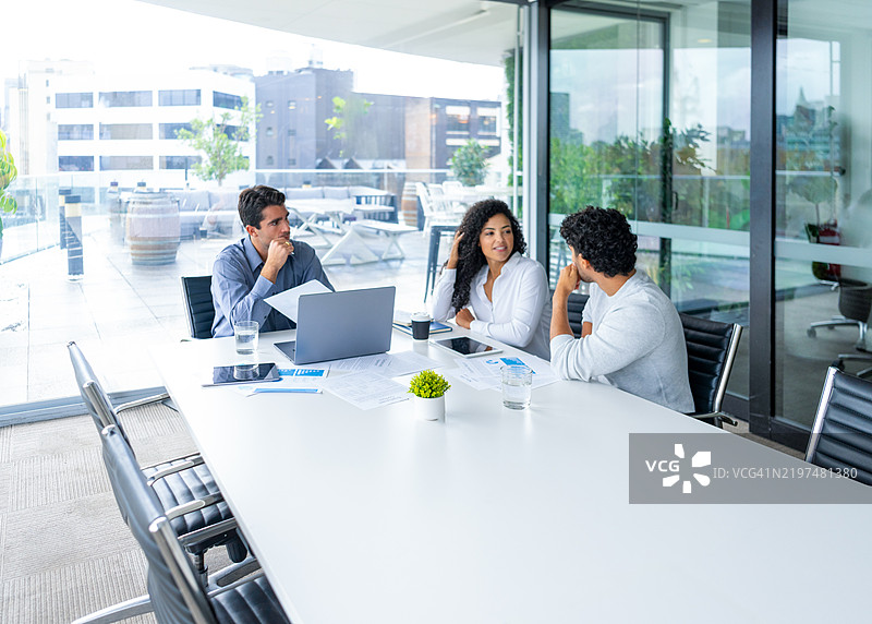 一对情侣在听一位商人、银行家或财务顾问讲解，他正在使用一台笔记本电脑。图片素材