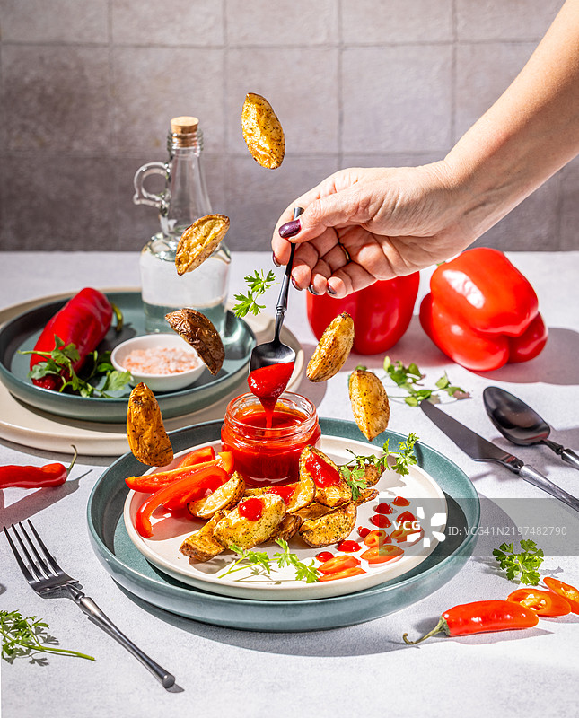 厨师在烤土豆上倒入辣酱和红椒图片素材