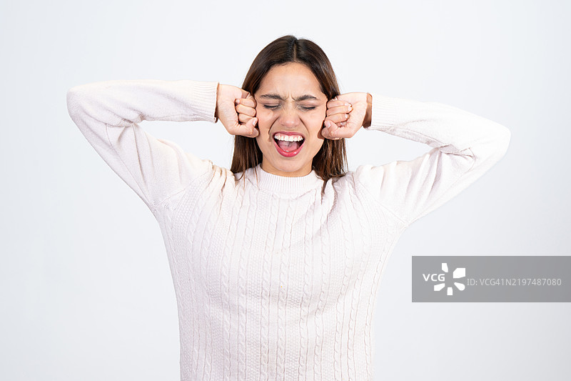 年轻女性捂住耳朵，因沮丧而尖叫图片素材