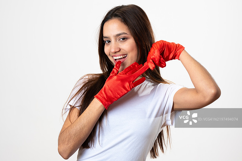 年轻女性戴着红色手套在白色背景上做搞笑表情图片素材