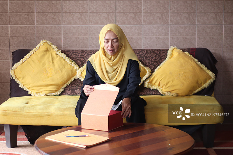 女人在拆包裹。图片素材