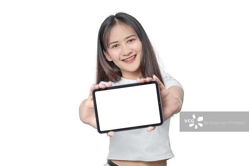 一位女性手持平板电脑，背景为白色。图片素材