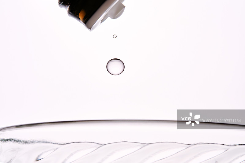 抗组胺滴剂或维生素D被滴入一杯水中。图片素材