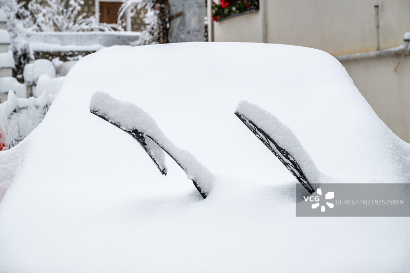 被雪覆盖的汽车，挡风玻璃刮水器可见图片素材