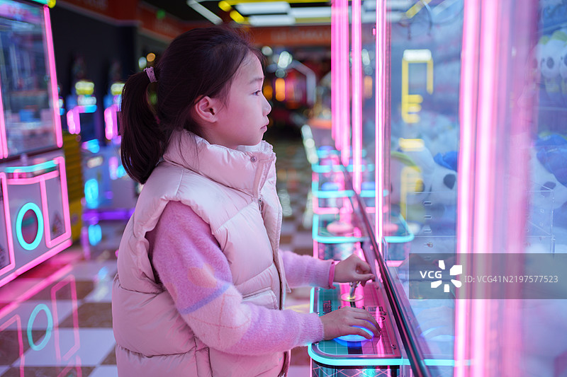 亚洲小女孩在玩抓娃娃机图片素材
