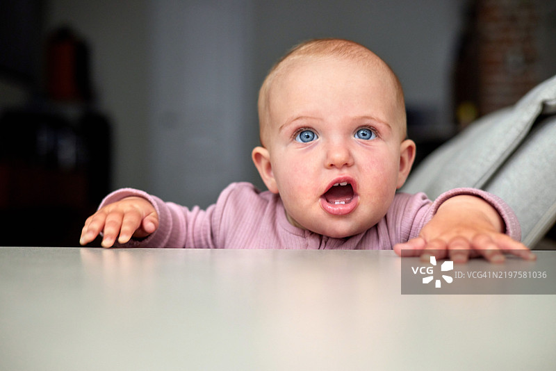 小女孩张嘴伸手去拿桌子上的东西图片素材