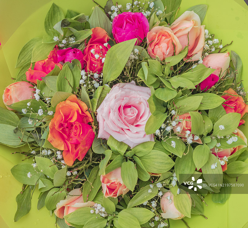 明亮多彩的花卉花束，搭配丰盛的绿叶，展示出充满活力的玫瑰和细腻的填充花，和谐而愉悦。图片素材
