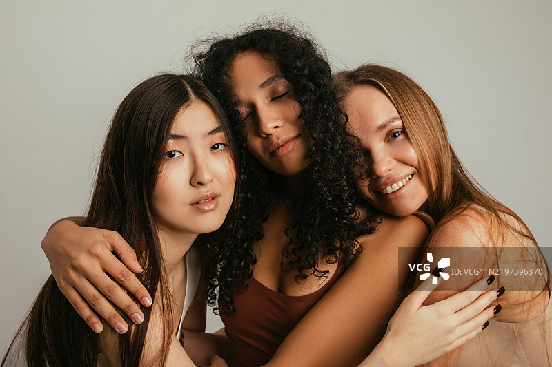 三位女性展示团结与自然美的多样性图片素材