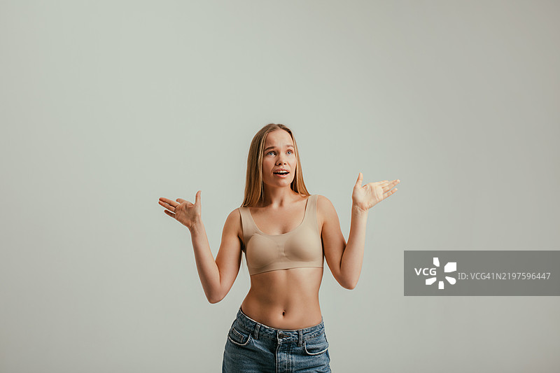 年轻女性在简约工作室环境中热情地做手势图片素材