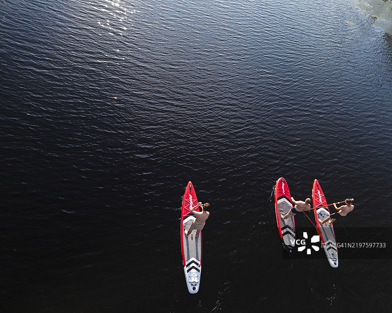 在基辅迷人的日落景色中，宁静水域上的立式划水冒险图片素材