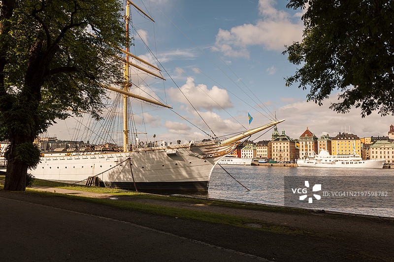 一艘停泊在大城市中心的帆船。图片素材