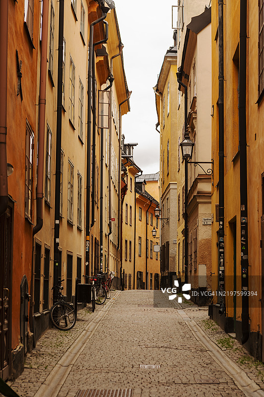 一条老城区的小巷，周围是古老房屋的外立面。图片素材