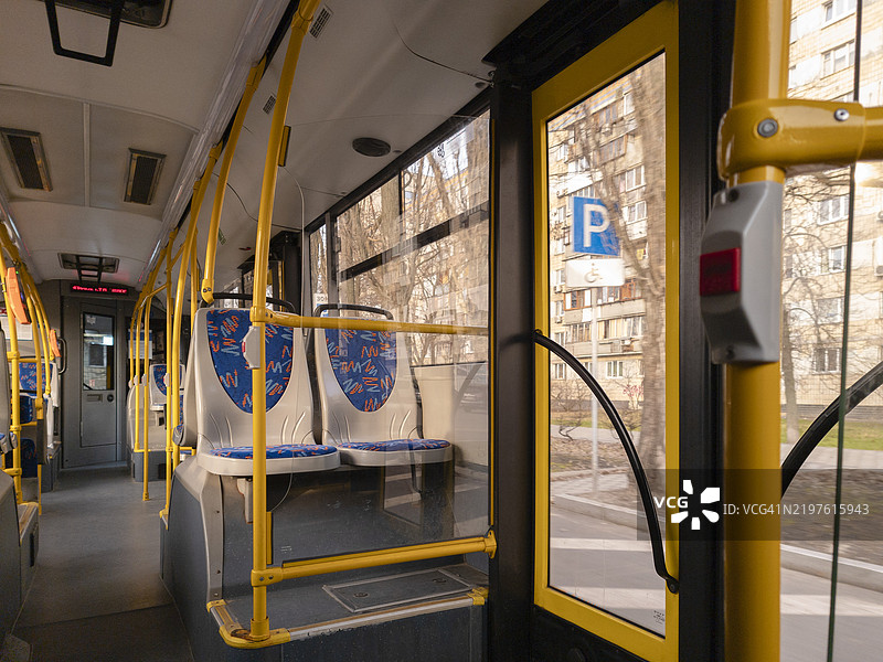 阳光明媚的日子里，基辅市内一辆公交车的内部景观，座椅色彩鲜艳，周围环境充满城市气息。图片素材