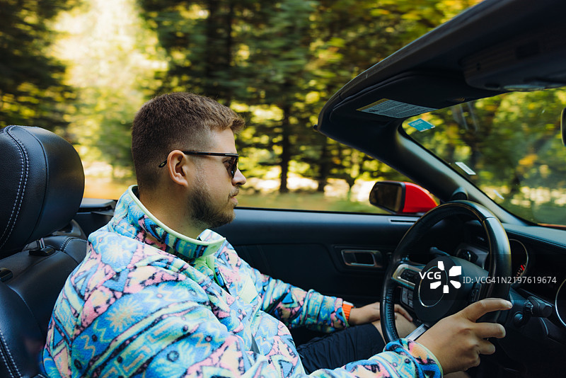 男子在森林中驾驶敞篷车图片素材