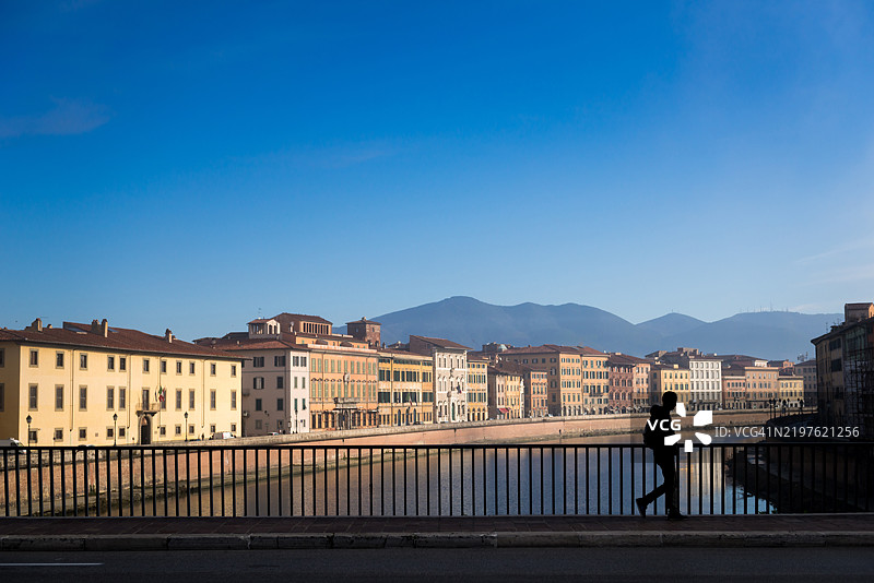 沿阿诺河的传统托斯卡纳风格建筑排成一行，背景是比萨市的法埃塔山景观，意大利图片素材