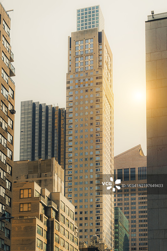 阳光照耀下的现代摩天大楼，繁忙的纽约市景象图片素材