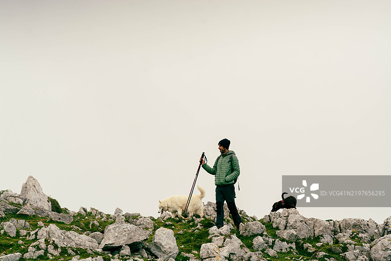 在山地风景中与狗一起徒步旅行的人图片素材