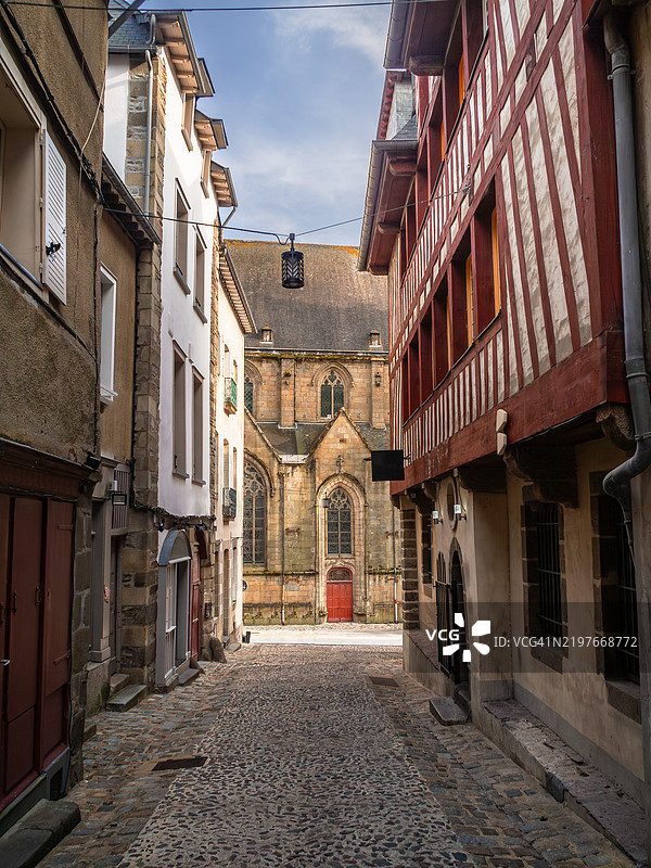 通过德瓦尔街(Rue Derval)俯瞰圣日耳曼教堂(Eglise Saint Germain),这是一条狭窄的鹅卵石街道,位于雷恩的历史区,两旁是15世纪的半木结构房屋,位于伊勒-维莱讷省 - 布列塔尼(Bretagne) - 法国。图片素材