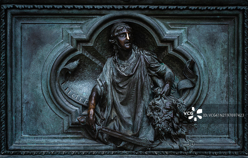 米兰大教堂（杜omo）主铜门上的大卫与歌利亚头颅的浮雕细节图片素材
