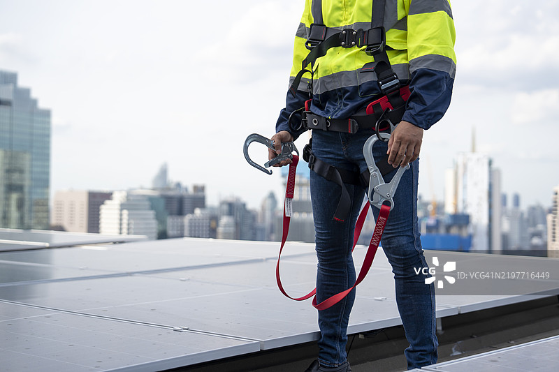 工人在高处佩戴安全带和安全绳作业图片素材