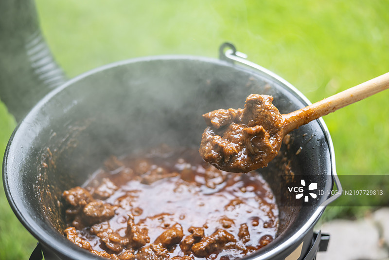 洋葱底料的牛肉在大锅中烹饪，这是制作匈牙利炖牛肉的下一步。图片素材