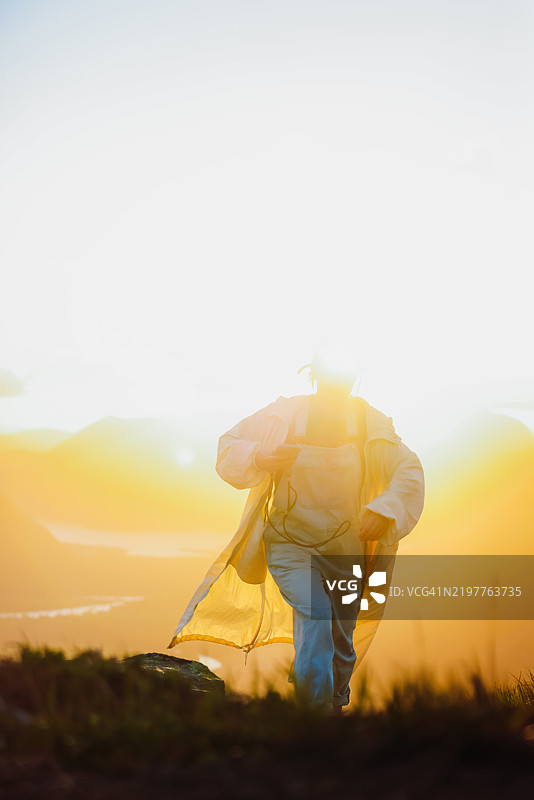女性登山者在山中露营，欣赏日落时分的美丽山谷景色图片素材