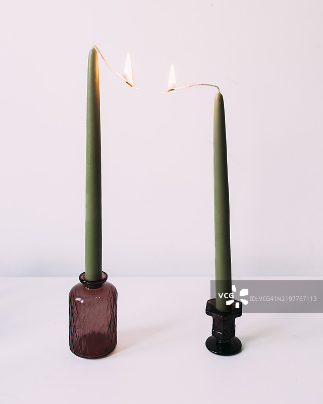 两根绿色蜡烛在白色背景上燃烧图片素材