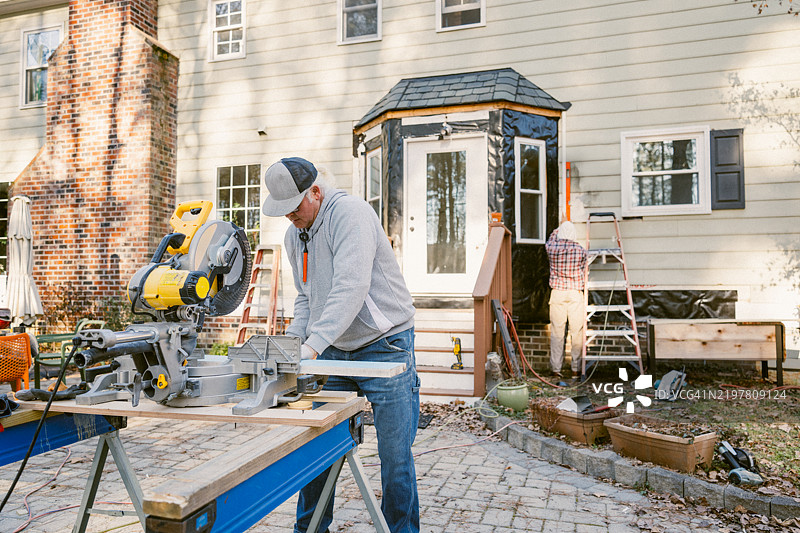 建筑工人在修理房子的外墙。图片素材
