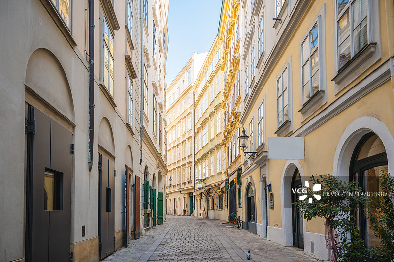 迷人的狭窄鹅卵石街道，周围是历史建筑，维也纳，奥地利图片素材