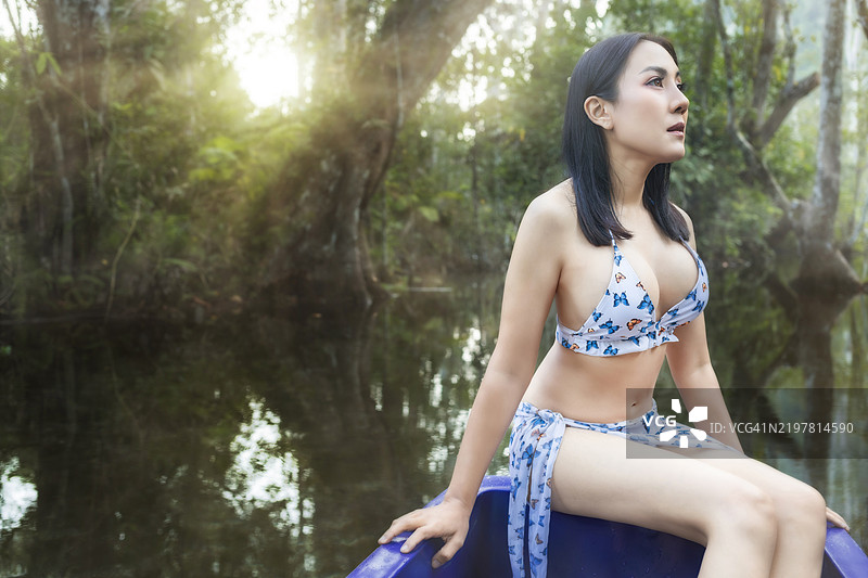 泰国森林中船上的美丽女孩图片素材