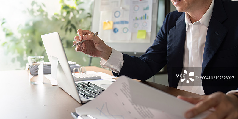 老年商人在审阅报告时讨论数据洞察。图片素材