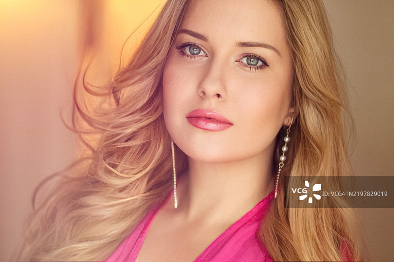 拥有蓝色眼睛和长而丰盈的金色柔软发型的女性图片素材