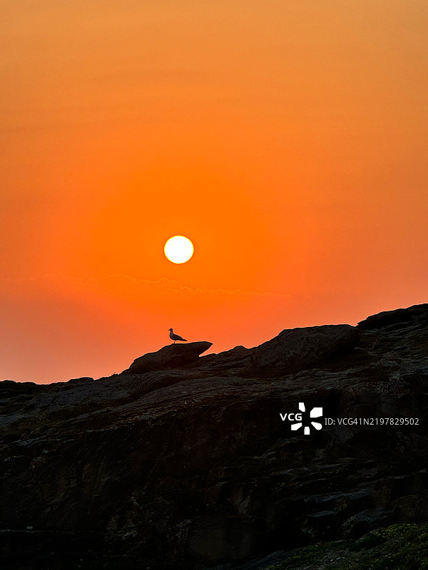 海洋与橙色天空的美丽景色，奎贝龙，布列塔尼，法国图片素材