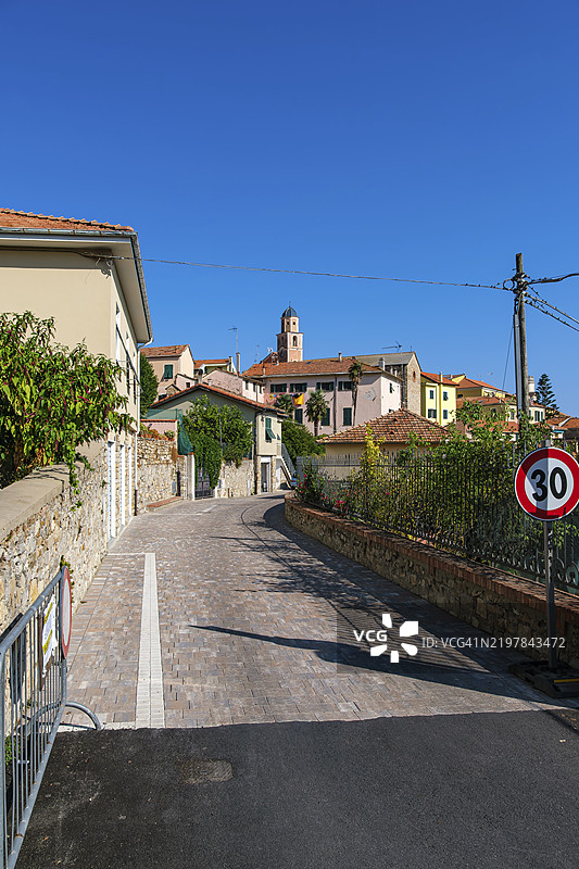 意大利利古里亚大区因佩里亚省迪亚诺卡斯特洛市历史市中心的建筑结构，背景是这座罗曼式教堂圣玛利亚升天的巴洛克塔楼。图片素材