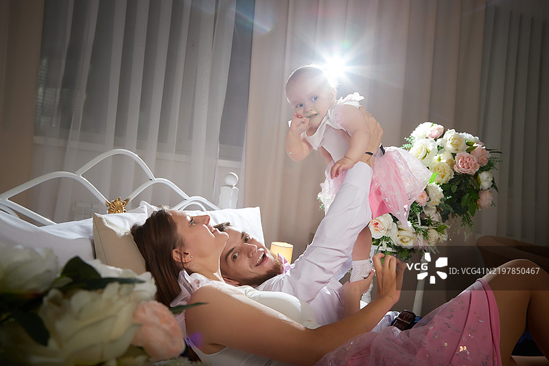 一家人和他们的女婴共享快乐时光，正在玩耍。图片素材