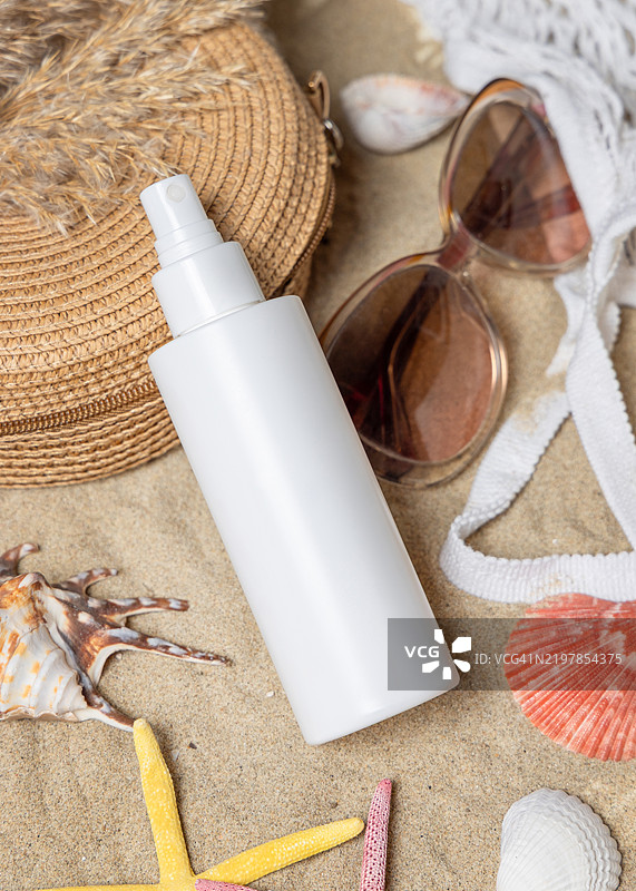防晒喷雾瓶、太阳镜、毛巾、沙滩上的海星和贝壳、化妆品展示模版图片素材